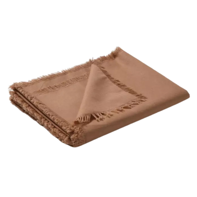 Folded terracotta tablecloth made of linen and cotton, featuring a soft feel, fringe edges, and a versatile design for any occasion.