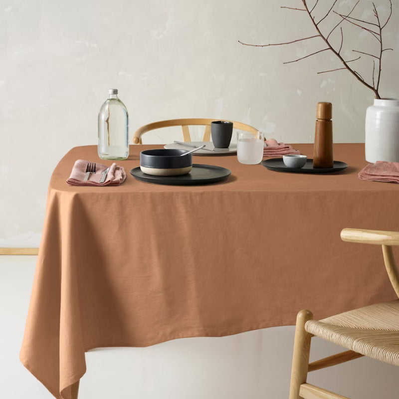 Packaging details of a terracotta cotton-linen tablecloth featuring a unique helm design, tied with a white ribbon, perfect for enhancing your dining decor.