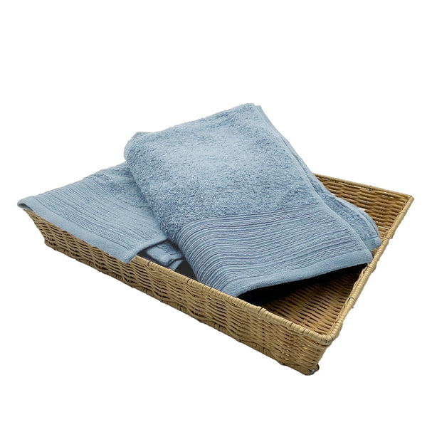 Two baby blue bath towels elegantly placed in a basket, highlighting their luxurious softness and stylish appeal for a refined bathroom.