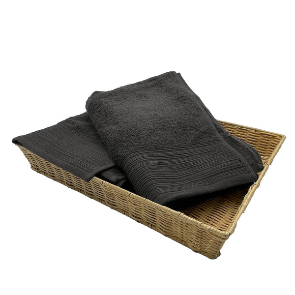 Two charcoal bath towels elegantly placed in a basket, highlighting their luxurious softness and stylish appeal for a refined bathroom.