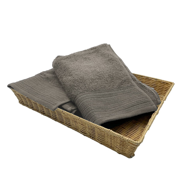 Two silver bath towels elegantly placed in a basket, highlighting their luxurious softness and stylish appeal for a refined bathroom.