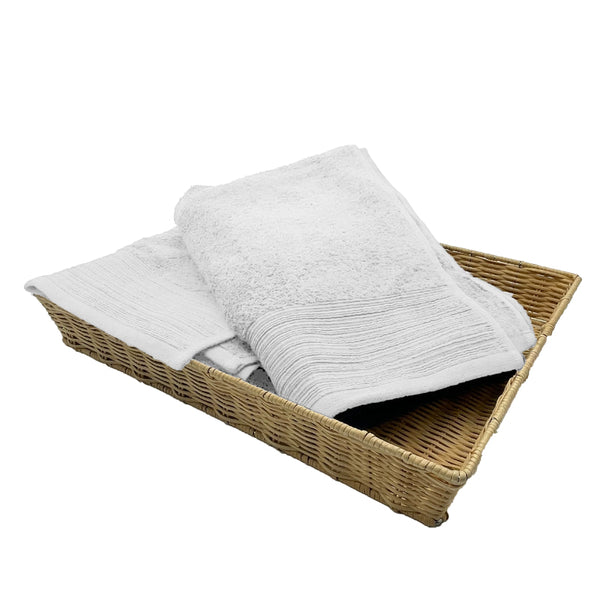 Two white bath towels elegantly placed in a basket, highlighting their luxurious softness and stylish appeal for a refined bathroom.