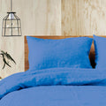 An indigo bed highlighting the luxurious comfort of the Jenny Mclean Doux Pure Linen Quilt Cover Set.