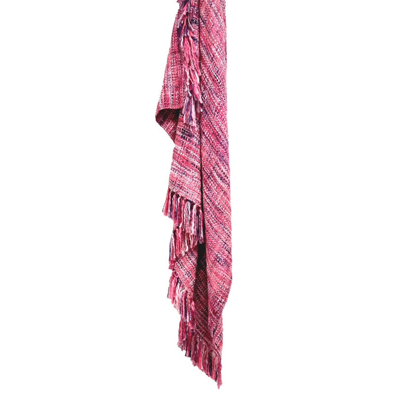 A lively pink throw rug with fringes, ideal for summer activities, enhancing both comfort and aesthetic appeal.