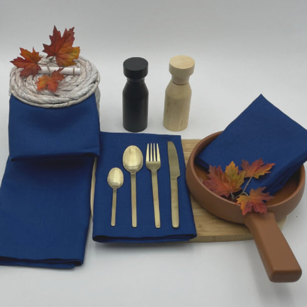 A dining table set with elegant Venice indigo linen napkins, spoons, and forks, showcasing sophistication and practicality for any occasion.