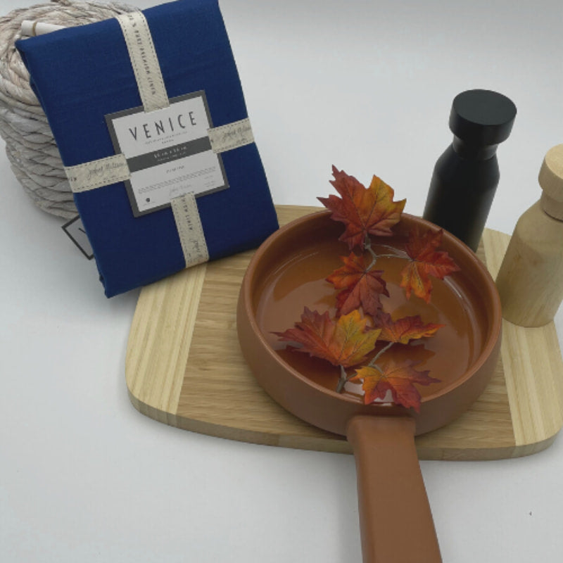 Packaging details of Venice indigo linen napkins accompanied by a wooden tray and kitchen things, perfect for an elegant table arrangement.