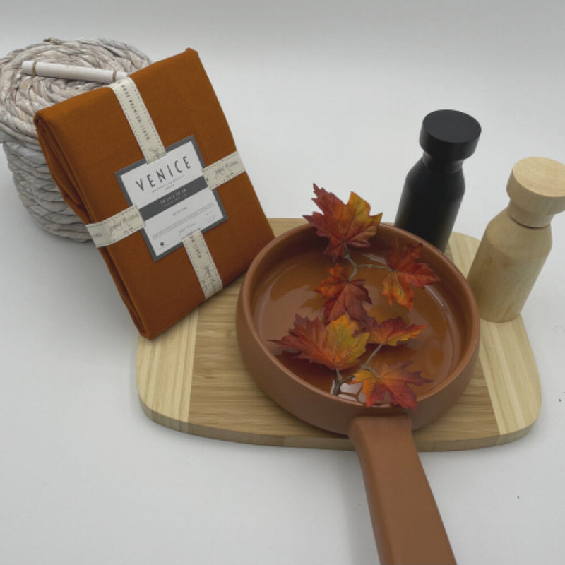 Packaging details of Venice terracotta linen napkins accompanied by a wooden tray and kitchen things, perfect for an elegant table arrangement.