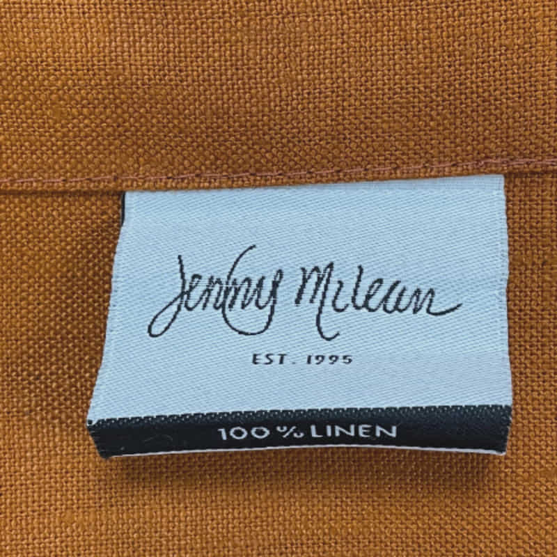 Front tag details of Venice terracotta linen napkin emphasizing the fabric used.