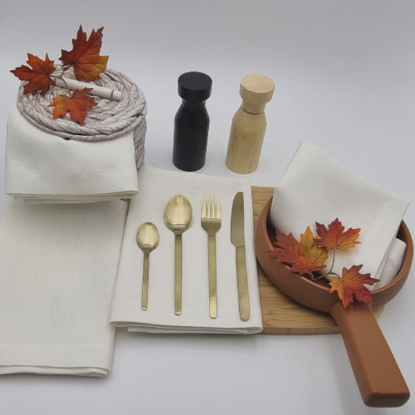 A dining table set with elegant Venice white linen napkins, spoons, and forks, showcasing sophistication and practicality for any occasion.