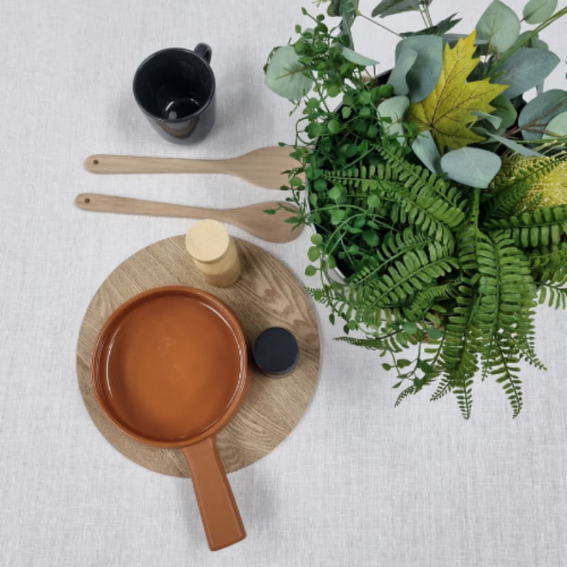 A table adorned with a pot of plants and kitchen things,  featuring a sophisticated RANS Venice Linen White Tablecloth.